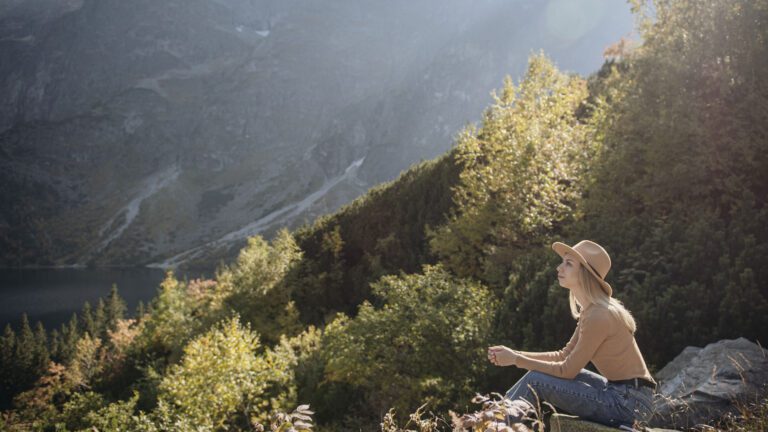 Woman Pondering on a Mountain | Rooted Counseling & Wellness | Healing Childhood Trauma: Benefits of Counseling | Childhood Trauma Counseling Draper Utah | Counseling For Childhood Trauma