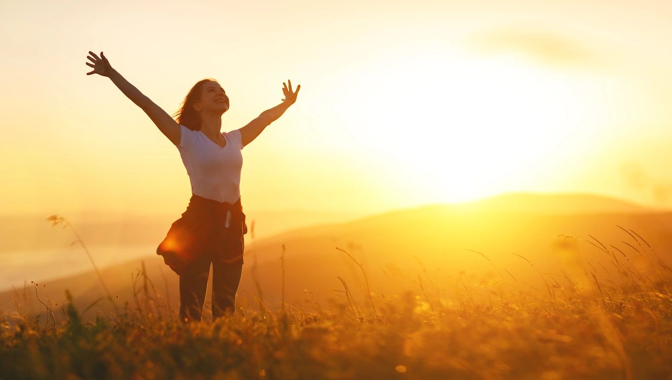 Woman with Arms Up at Sunset | Embracing Self-Compassion | Rooted Counseling and Wellness | Draper Therapy and Wellness Center